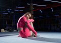 Woman in Pink Activewear Sitting on a Boxing Ring while Looking at the Camera