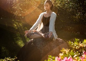 Woman Meditating on Rock