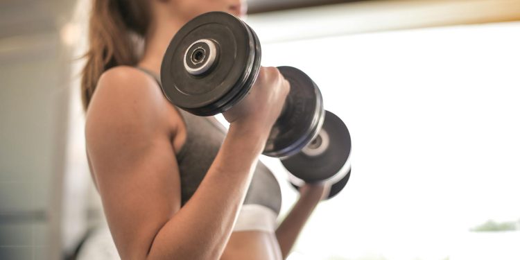 Woman in Gray Sports Bra Holding Black Dumbbell