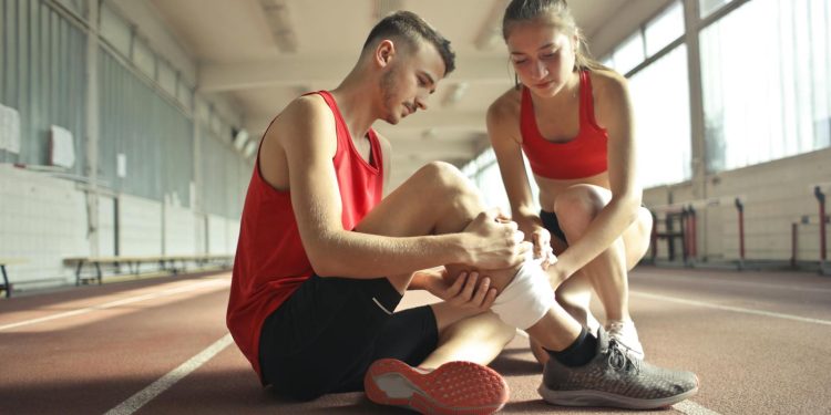 Woman Wrapping Man's Leg with Bandage