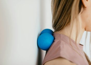 Close-Up Photo of a Woman Pressing Her Neck on a Stress Ball