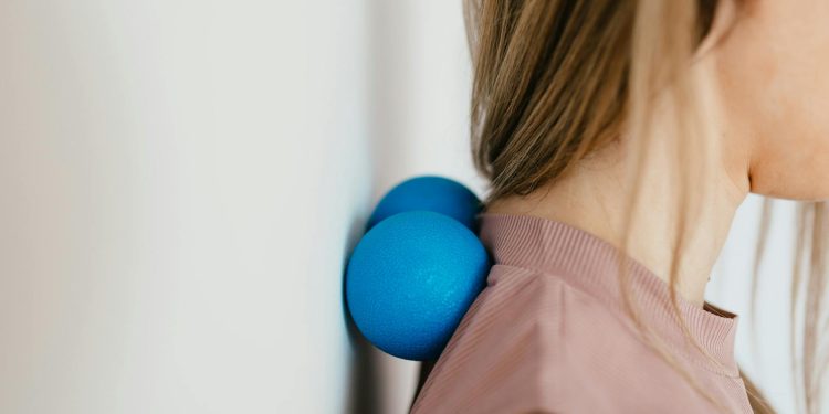 Close-Up Photo of a Woman Pressing Her Neck on a Stress Ball