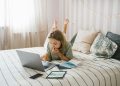Woman Lying on Bed While Using a Laptop