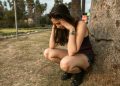 Photo of a Woman Crouching while Her Hands are on Her Head
