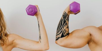 A Woman and a Man Holding Dumbbells