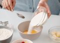 Person Pouring Powdered Sugar in a Bowl