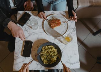 People Holding a Fork and Knife on the Table with Vegan Food