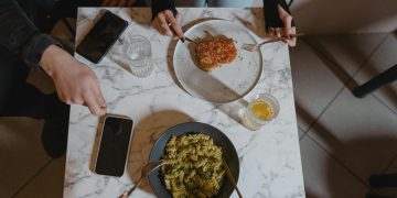 People Holding a Fork and Knife on the Table with Vegan Food