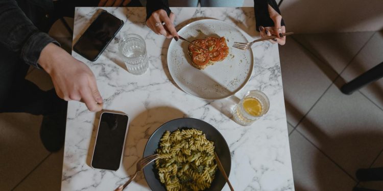 People Holding a Fork and Knife on the Table with Vegan Food