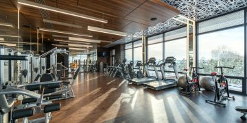 Interior of modern fitness club with various machines and equipment