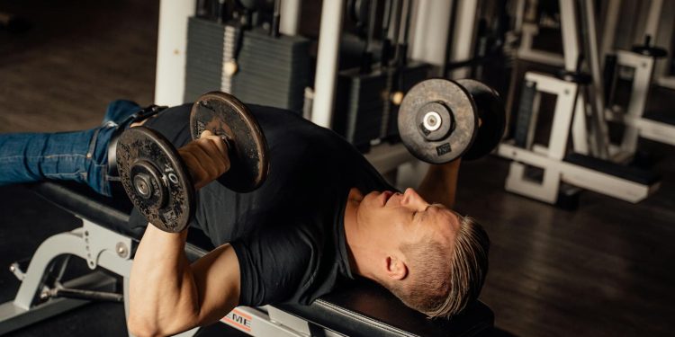 A Man Doing a Dumbbell Chest Press