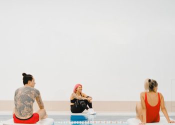 People Sitting on Swimming Boards in a Swimming Pool