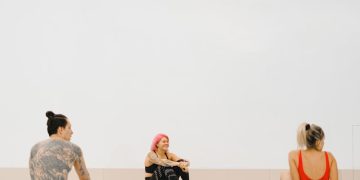People Sitting on Swimming Boards in a Swimming Pool