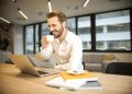 Depth of Field Photo of Man Sitting on Chair While Holding Cup in Front of Table